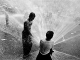 Children Playing in the Spray of an Open Fire Hydrant to Escape the Ongoing Heat Wave Photographic Print by Peter Stackpole