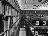 Man Reading Book Among Shelves on Balcony in New York Public Library Premium Photographic Print by Alfred Eisenstaedt