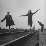 Two Young Ballet Russe Dancers Balancing on the Railroad Tracks in the Station While on Tour Photographic Print by Myron Davis