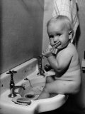 Adorable Baby Brushing Teeth While Sitting in Sink Lámina fotográfica Adorable Baby Brushing Teeth While Sitting in Sink Lámina fotográfica