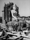 Convoy Truck Drivers Standing Around Wrecked Buddha Reproduction photographique sur papier de qualité par Jack Wilkes