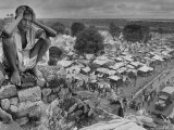 Boy Sitting on Rock Ledge Above Refugee Camp Premium Photographic Print by Margaret Bourke-White