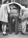 View of the Backsides of Two Men Leaning over Looking at a Small Sports Car Photographie par Gordon Parks