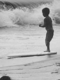 Little Boy Standing on a Surf Board Staring at the Water Photographie par Allan Grant