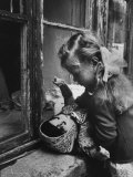 3 Year Old Child Playing with Doll on Window Sill of Apartment Premium Photographic Print by Stan Wayman