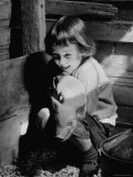 Jan Bruene with Piglet of a Group 2-3 Weeks Old, Kept in Basement of Home Reproduction photographique sur papier de qualité par Gordon Parks