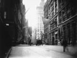 People and Horse Drawn Carts on Wall St, Where American Flags Fly from Buildings Photographic Print by George B. Brainerd