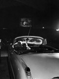 Young Couple Cuddling as They Watch a Movie at Drive in Theater Premium Photographic Print by Francis Miller