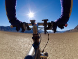 A Man Cycling Across a Desert Landscape Photographie par Barry Tessman