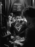 Teenage Boy Peering Into Window of Ticket Booth at a Movie Theater Photographie par Yale Joel