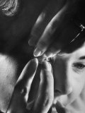 Woman Cautiously Placing a Contact Lens in Her Eye Premium Photographic Print by Al Fenn