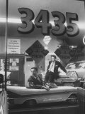 Men Standing in the Window of a Car Dealership Photographie par Francis Miller