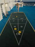 Woman Playing Shuffleboard Game on a Cruise Ship Lámina fotográfica por Todd Gipstein