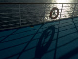Life Preserver Hanging on a Railing of a Cruise Ship Deck Photographic Print by Todd Gipstein