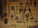 An Assortment of Hand Tools Hang on a Plank Wall Photographic Print by Raul Touzon