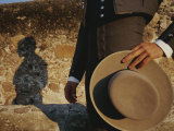 Un homme en robe traditionnel jette une ombre sur un mur de pierre Photographie par Raul Touzon