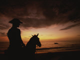 Horseback Rider Silhouetted on a Beach at Sunset, Costa Rica Photographie par Michael Melford