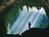 A Man Stands Below the Mouth of a Giant Cave Photographic Print by David Boyer
