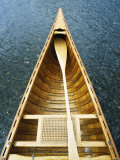 The Bow and Oar of a Handmade Wooden Canoe Resting in Water Photographic Print