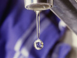 A Close-up of a Faucet with a Single Drop of Water Coming out of It Photographic Print by Todd Gipstein