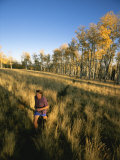 A Man Runs Through a Meadow of Tall Grass Near Mt. Elden Photographic Print by John Burcham
