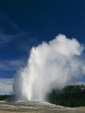 A Geyser Erupts at Yellowstone National Park Photographic Print by Paul Nicklen