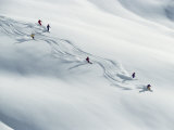 Six Skiers Make Their Way Down a Snow-Covered Hill Photographie par Paul Chesley
