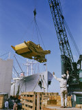 A Ship Being Loaded with Farm Equipment Photographic Print by Justin Locke