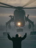 A Man Guides a Landing Helicopter Photographie par Lowell Georgia