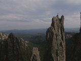 A Climber Stands Atop Khyyam Spire in South Dakota Photographie par Bobby Model