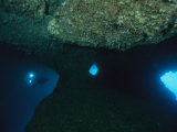 A Diver Explores an Underwater Formation Known as the Blue Hole Photographic Print by Tim Laman