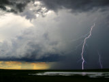 Lightning Cracks in a Cloud-Filled Sky with Rain Falling in Distance Photographic Print by Randy Olson