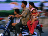 Young Family on Motorcycle., Phnom Penh, Cambodia Photographic Print by John Banagan