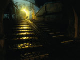 Silhouetted Person Walking Up Lamp-Lit Cobblestone Street, Sighisoara, Romania Photographic Print by David Greedy