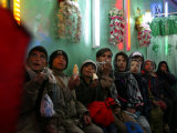 Afghan Boys Watch a Movie on a Television, Unseen, as They Eat Ice Cream at an Ice Cream Shop Photographie par Rodrigo Abd