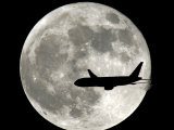 A Jet Plane Passes in Front of the Full Moon Above Surfside, Fla. Photographie