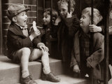A Little Boy Holding a Banana Whilst Other Children Gaze Longingly at It Photographie