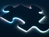 Black Puzzle Piece with Blue Light Shining Behind It Lámina fotográfica