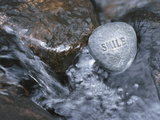 Rock with the Word Smile in Rushing Water Fotografisk tryk