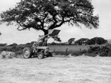 Harvesting with an International Cutter by a Massey-Fergusson 35 Tractor Fitted with a Mill Loader Valokuvavedos Harvesting with an International Cutter by a Massey-Fergusson 35 Tractor Fitted with a Mill Loader Valokuvavedos