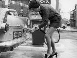 The Modern Female Petrol Pump Operator Refuelling a Car in Her Mini Skirt Fotografická reprodukce
