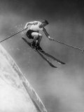 Man in a Vest in Mid-Air as He Skis Down a Steep Mountain Fotografisk tryk Man in a Vest in Mid-Air as He Skis Down a Steep Mountain Fotografisk tryk
