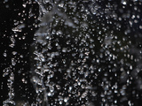 Close-up of Glittering Illuminated Falling Water Droplets Photographic Print