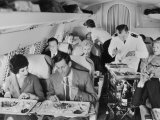 An Airline Steward and Air Hostess Serve a Roast Meal to Flight Passengers Photographie