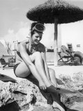 Young Woman in a Bikini Prepares to Go Snorkelling by Putting on Her Rubber Flippers Photographic Print