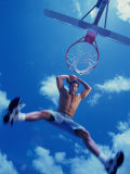 Low Angle View of a Young Man Slam Dunking a Basketball Photographic Print