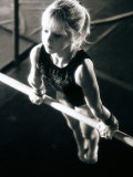 Girl Performing Gymnastics on Uneven Parallel Bars Photographie
