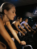 Two Young Women And a Young Man Exercising in a Gym Photographic Print