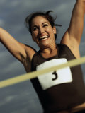 Low Angle View of a Female Athlete with Arms Raised Photographic Print