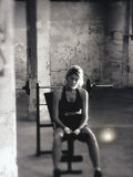 Young Woman Sitting on a Weight Bench Photographic Print